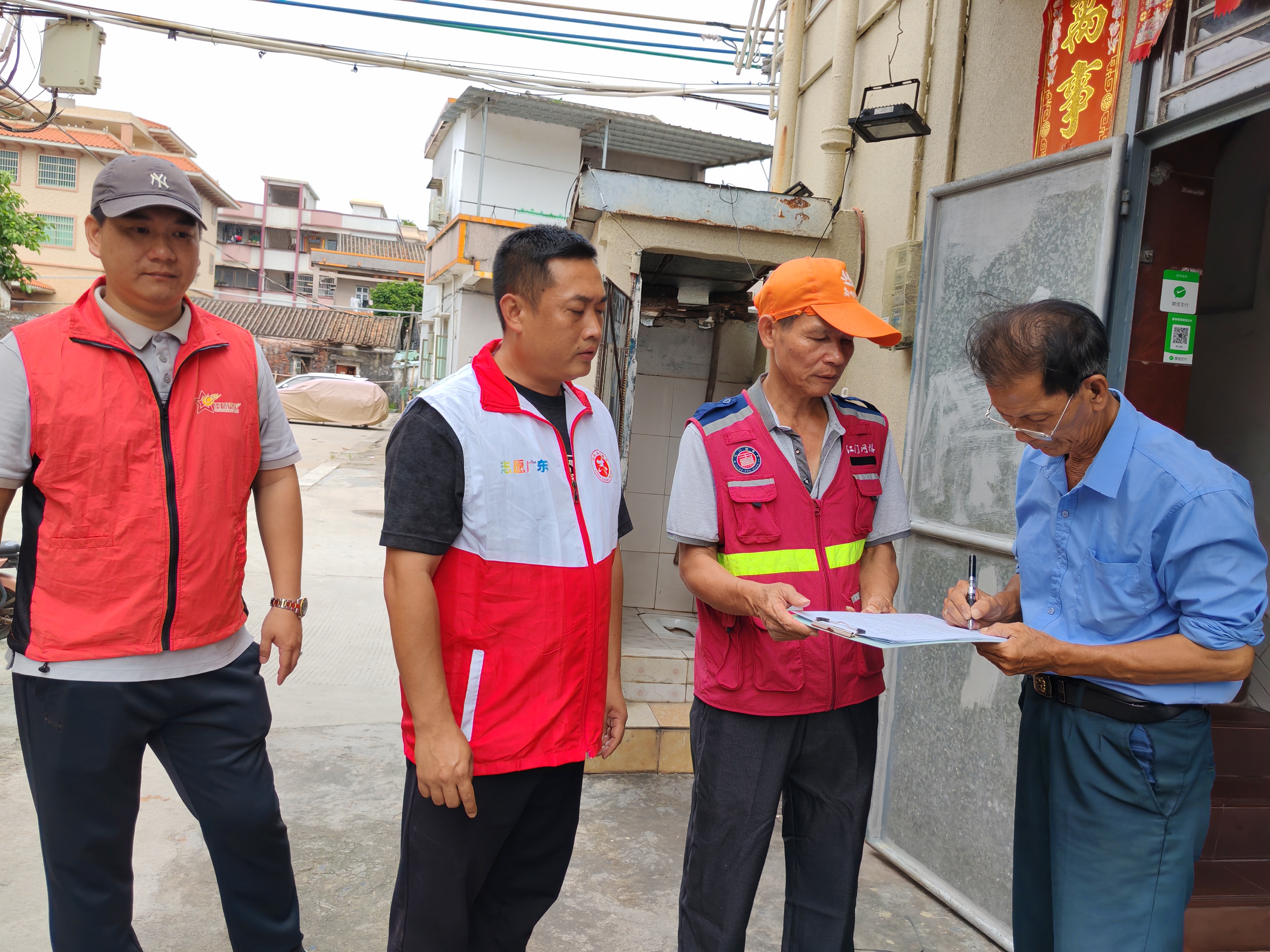 崖门镇兵书记黄贤豪（2左），带领村“两委”干部坚守岗位，对村里老旧危房、临时建筑等重点领域开展全方位、拉网式的隐患排查并签上停工责任书，挨家挨户敲门通知防汛事宜.jpg
